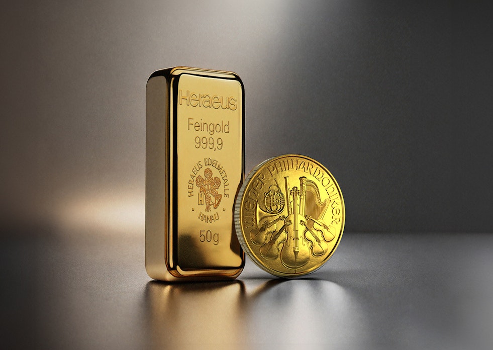Vor einem dunklen Hintergrund stehen ein Goldbarren und eine Wiener Philharmoniker Goldmünze. Edelmetall-Sparpläne von Golden Gates.