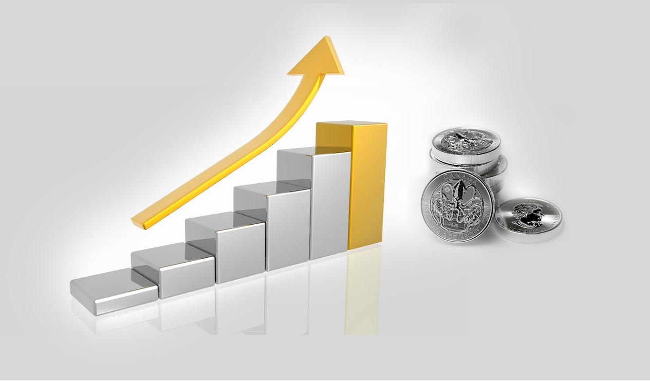 Auf dem Bild ist ein steigendes Balkendiagramm, über welchem ein goldener Pfeil schwebt, zu sehen. Die stellt die steigende Entwicklung von Silber dar. Daneben sind Silbermünzen abgebildet. Sparen Sie in Silber mit den Sparplänen oder der Einmalanlage von Golden Gates.