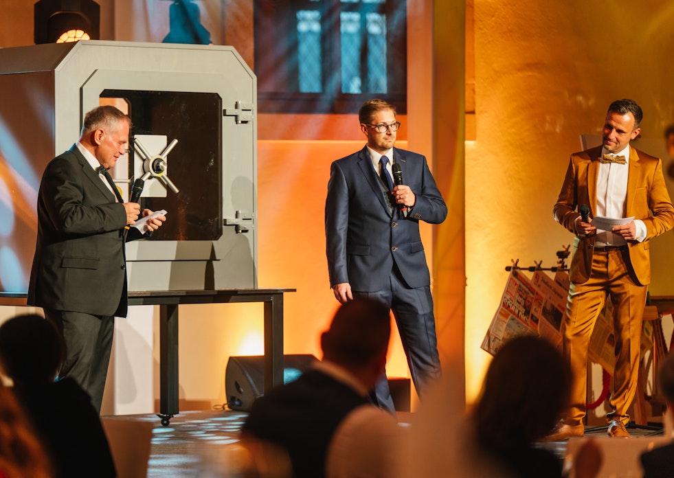 Auf der Tribüne stehen die Gründer der Golden Gates Edelmetalle AG, Herbert und Constantin Behr, und eröffnen die Jubiläumsfeier „10 Jahre Golden Gates“.