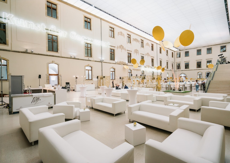 Der Festsaal im Albertinum in Dresden. Hier stehen in einem großen, hellem Raum weiße Sofas mit kleinen Tischen. In einer Ecke des Raumes ist ein Rednerpult aufgebaut.