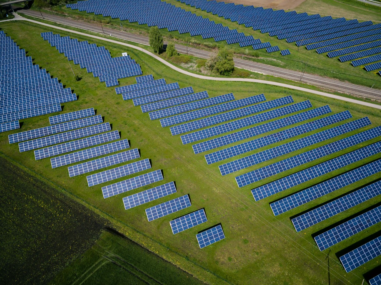 Auf einer Wiese stehen Solarpaneele. Sparen auch Sie in kritische Rohstoffe mit den Sparplänen von Golden Gates.